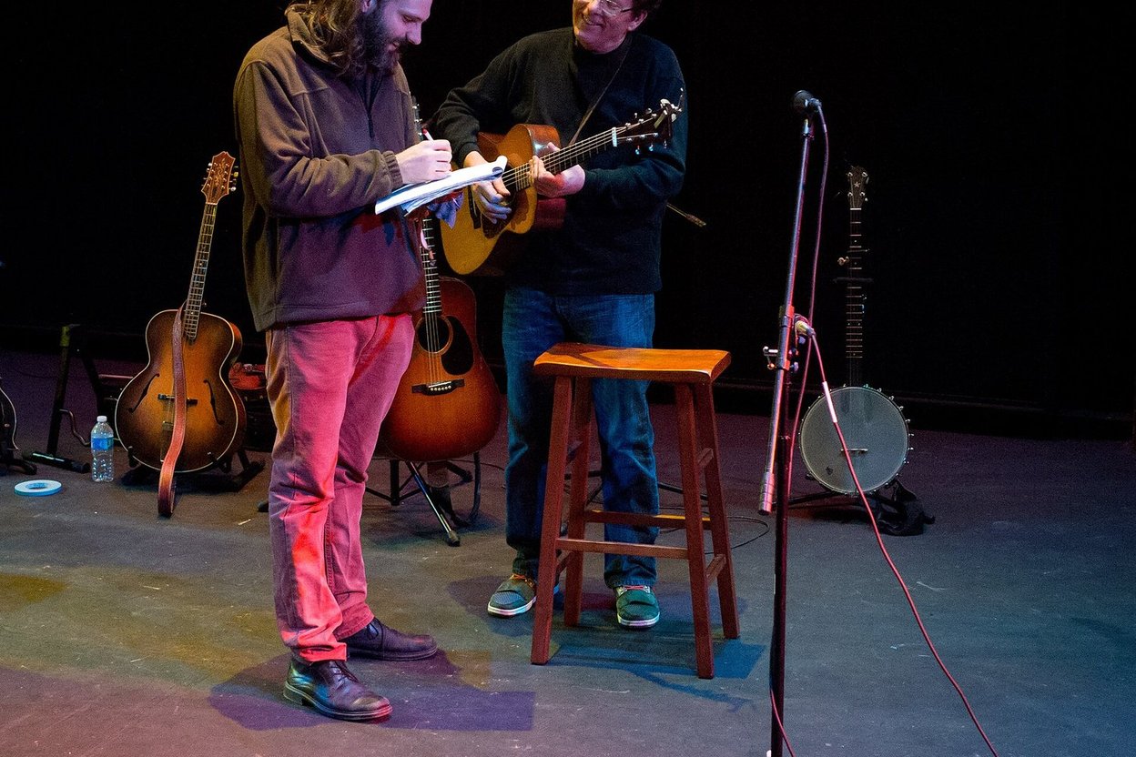 Musicians performing with banjo and guitar on a stage
