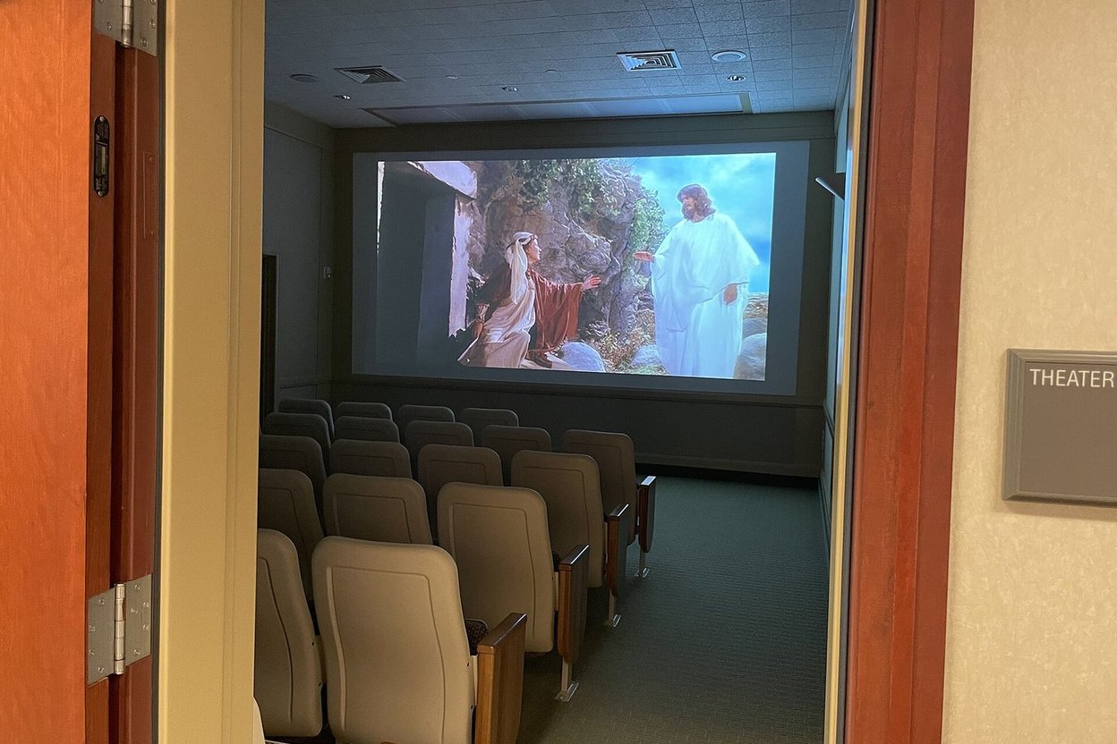 A small movie theater with the screen lit