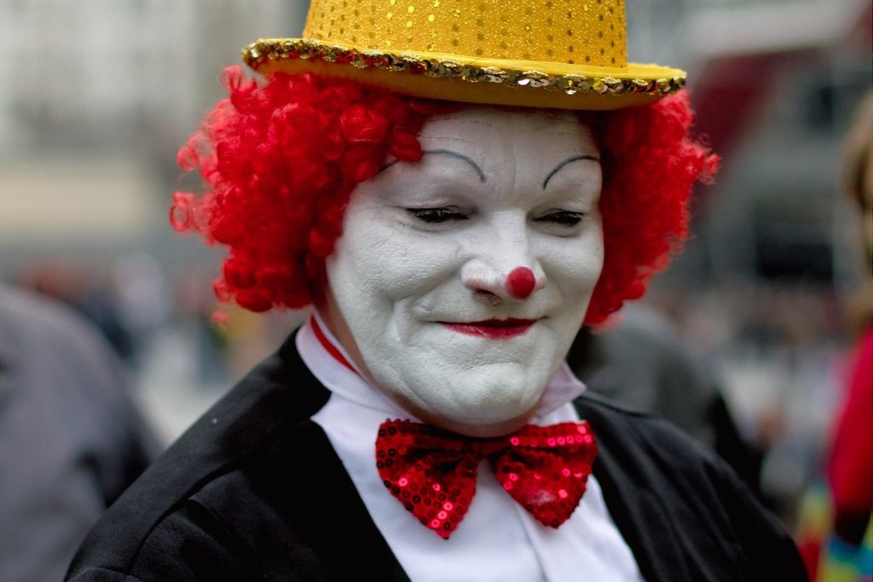 Halloween pop-up store display featuring rubber clown masks with painted grins