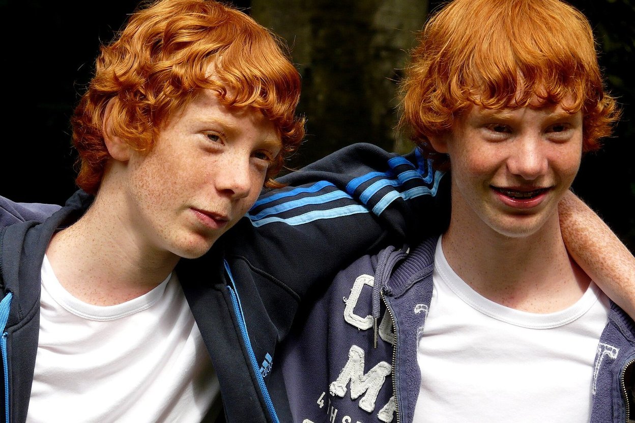Redheaded twin brothers smiling together