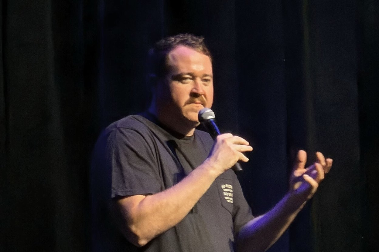 Shane Gillis performing stand-up with a microphone at Hard Rock Live in Hollywood, Florida, in 2025.